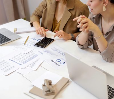 pexels-photo-6779716-6779716 Two professionals collaborating on financial documents in a modern office setting.